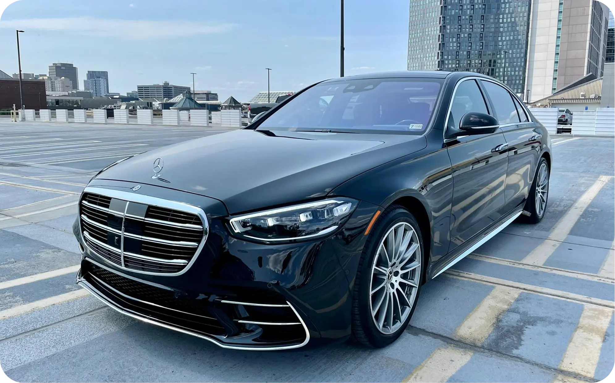 Black sedan car service waiting at JFK terminal arrivals for pre-booked airport pickup